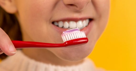 How to cure gum disease without a dentist - Girl with toothbrush in mouth.